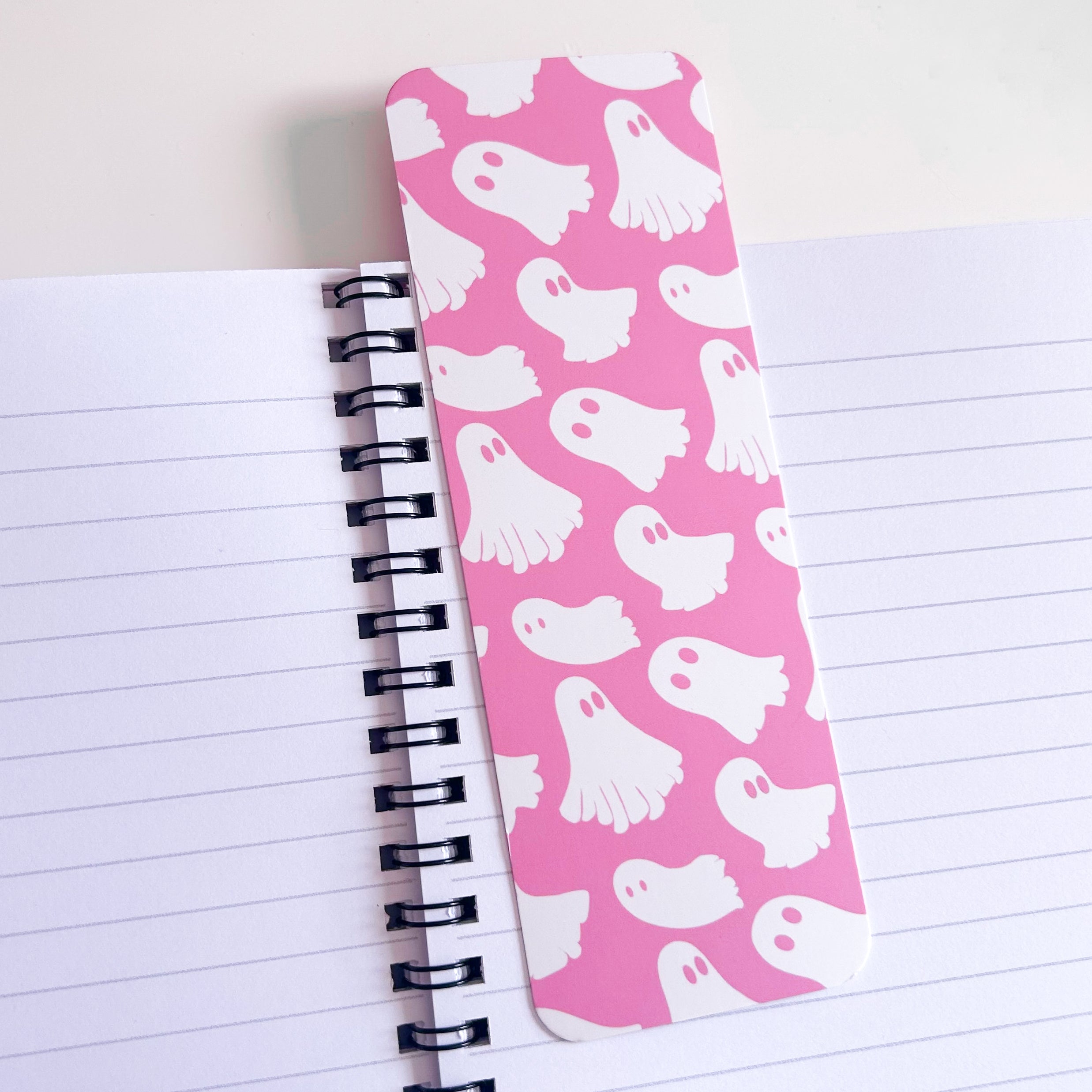 Pink bookmark with ghost pattern on a notebook page