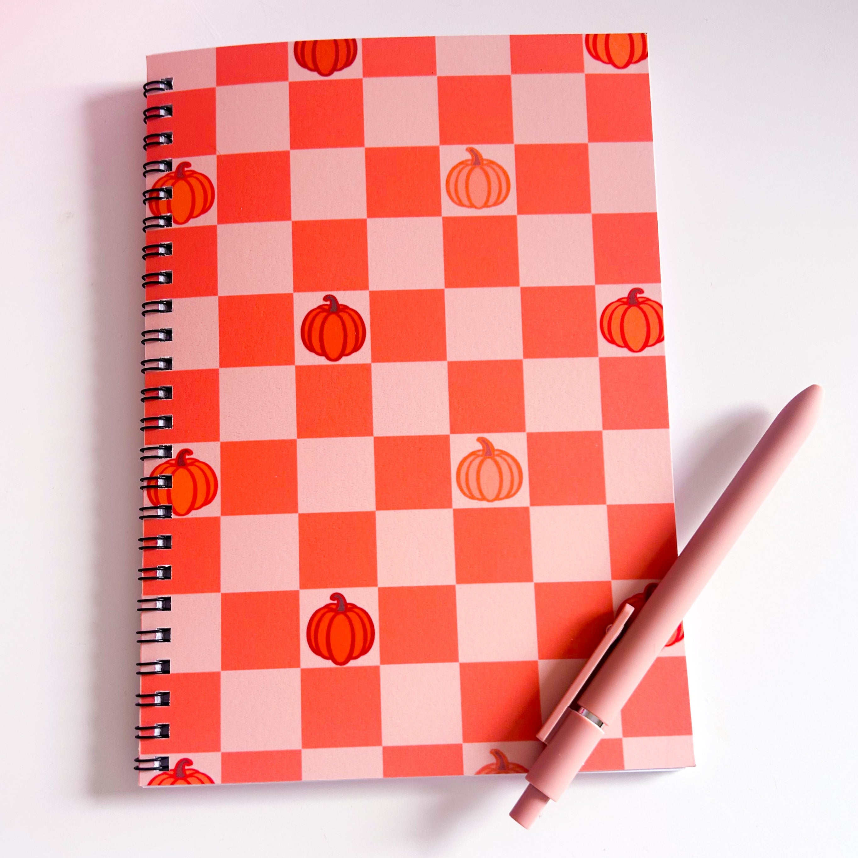 Notebook with orange checkered pumpkin pattern on a white background